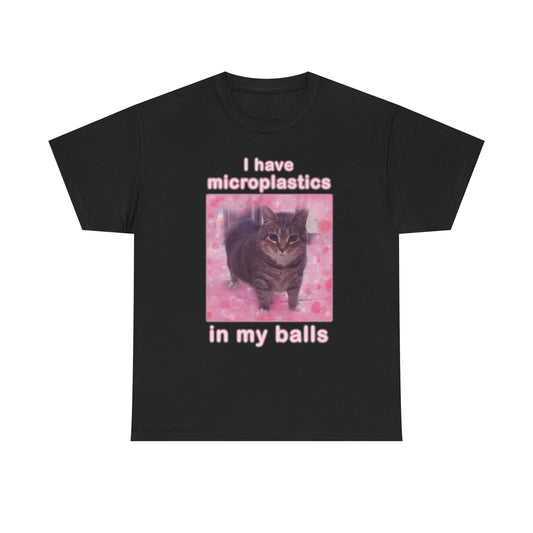 This image features a black crew neck t-shirt with a bold, humorous print. The front of the shirt displays a graphic with the phrase "I have microplastics in my balls" in white text, positioned over a vivid pink background that adds a striking contrast.